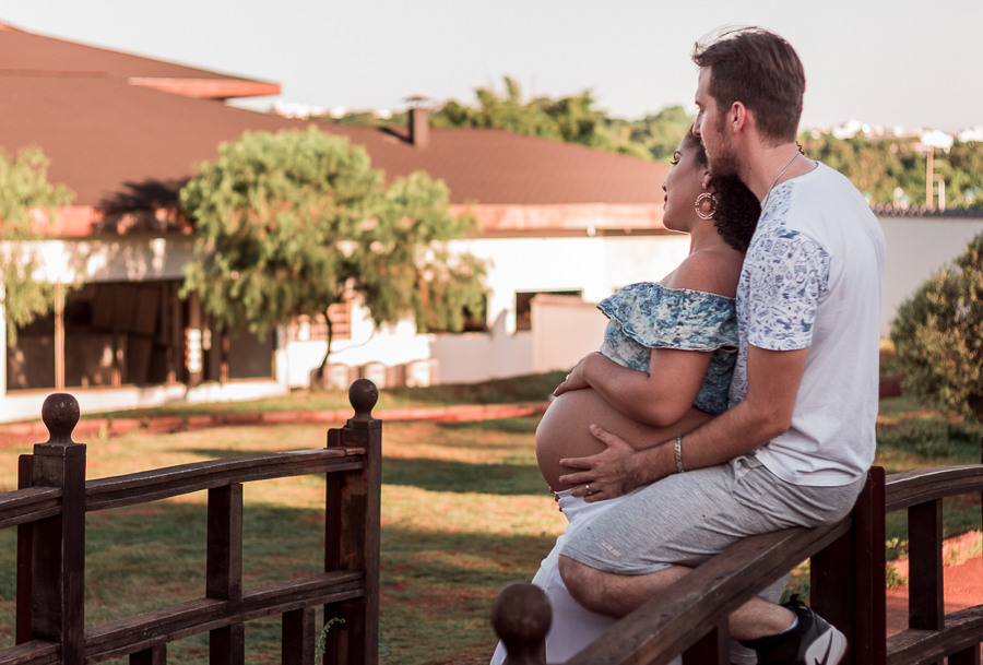 ENSAIO FOTOGRAFICO DE GESTANTES NO PARQUE DO JAPAO EM UMA TARDE ENSOLARADA EM MARINGA PARANA BRASIL NA IMAGEM O CASAL ESTA EM UMA PONTE ESTILO JAPONESA OLHANDO PARA O HORIZONTE ENQUANTO O PAI FAZ CARINHO NA BARRIGA DA MAE