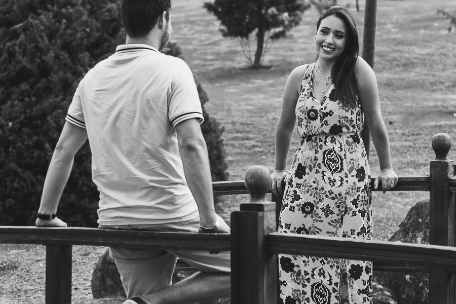ENSAIO FOTOGRÁFICO PRÉ-WEDDING PRE WEDDING PREWEDDING DE CASAL PARQUE DO JAPAO MARINGA PARANA NA FOTO O CASAL SENTADO EM UMA PONTE TROCAM OLHARES FOTO EM PRETO E BRANCO