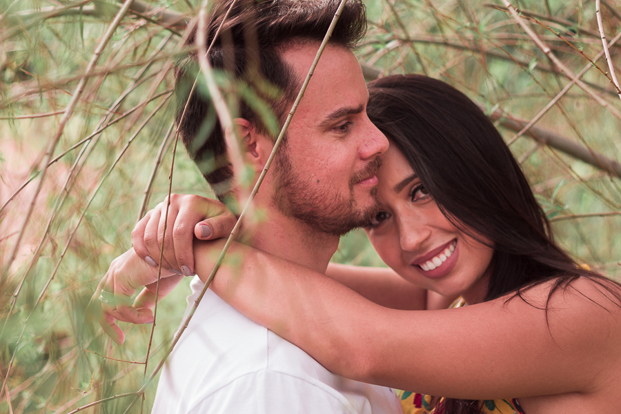ENSAIO FOTOGRÁFICO PRÉ-WEDDING PRE WEDDING PREWEDDING DE CASAL PARQUE DO JAPAO MARINGA PARANA NA FOTO A NOIVA OLHA DIRETAMENTE PARA A CAMERA ENQUANTO ABRACA O NOIVO