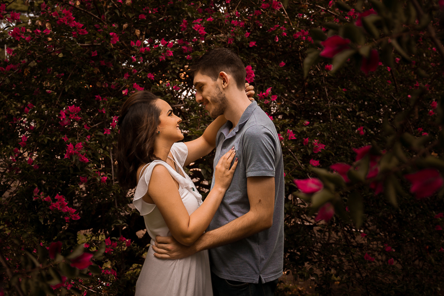 PRE CASAMENTO REALIZADO NO BOSQUE DAS GREVILEAS E NA LINHA DO TREM EM MARINGA NO PARANA NA IMAGEM AS FLORES ESTAO EM VOLTA DO CASAL QUE ESTÁ ABRACADO E TROCANDO CARINHOS
