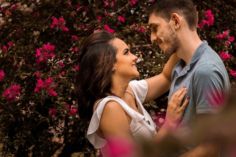 PRE CASAMENTO REALIZADO NO BOSQUE DAS GREVILEAS E NA LINHA DO TREM EM MARINGA NO PARANA NA IMAGEM AS FLORES ESTAO EM VOLTA DO CASAL QUE ESTÁ ABRACADO E TROCANDO CARINHOS