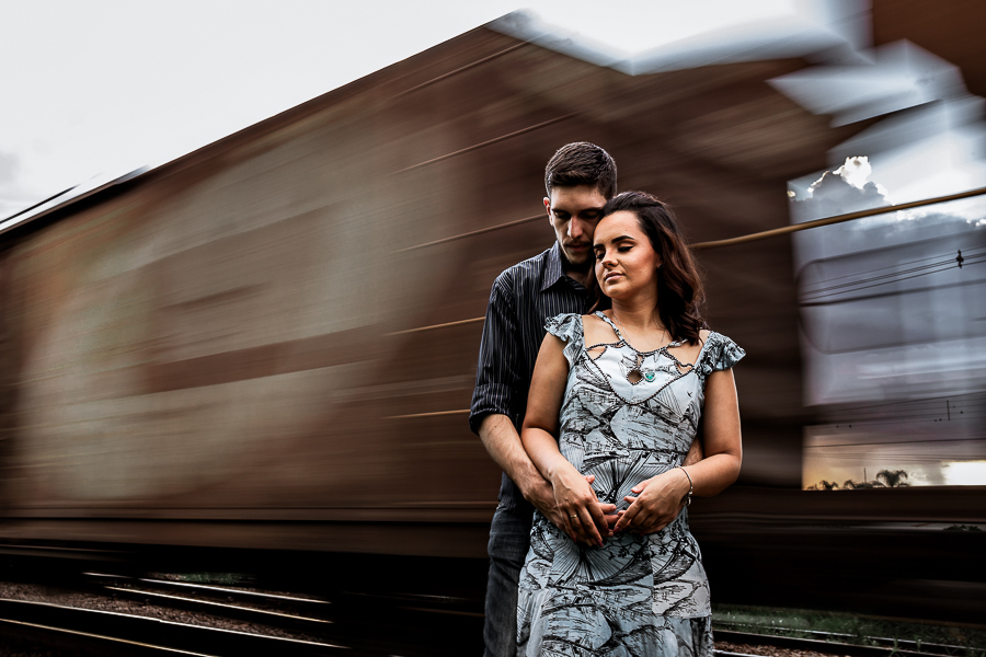 PRE CASAMENTO REALIZADO NO BOSQUE DAS GREVILEAS E NA LINHA DO TREM EM MARINGA NO PARANA NA IMAGEM O CASAL APARECE ABRACADOS COM UM TREM EM MOVIMENTO NO FUNDO USAMOS A LONGA EXPOSICAO PARA MANCHAR O MOVIMENTO