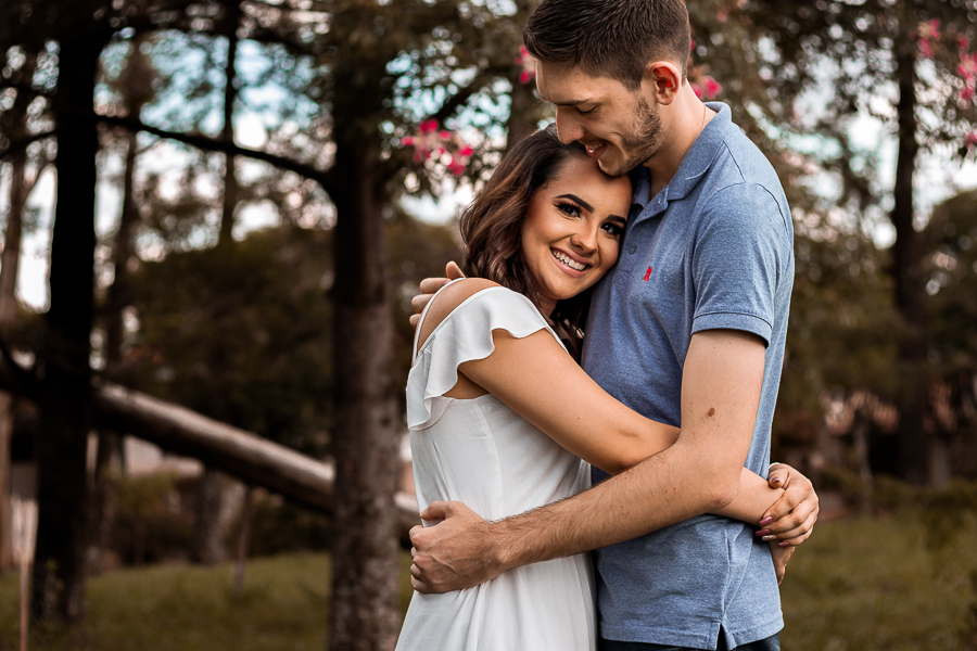 PRE CASAMENTO REALIZADO NO BOSQUE DAS GREVILEAS E NA LINHA DO TREM EM MARINGA NO PARANA NA FOTO DO PRE WEDDING O CASAL APARECE ABRACADO COM A NOIVA OLHANDO DIRETAMENTE PARA A CAMERA
