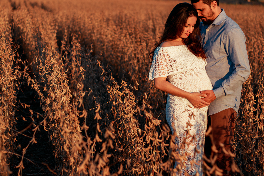 ENSAIO FOTOGRAFICO DE GESTANTE GESTACAO REALIZADO EM MARINGA NO PARANA NA IMAGEM A MAMAE APARECE COM UM VESTIDO BRANCO NA IMAGEM OS PAPAIS ESTAO ACARICIANDO O SEU FILHO ANTONIO