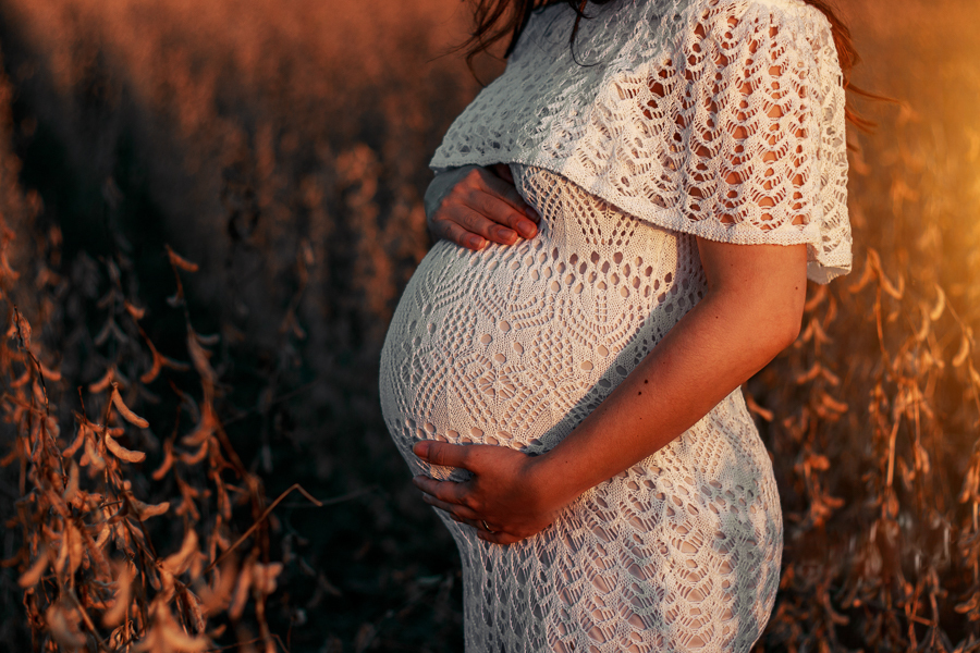 ENSAIO FOTOGRAFICO DE GESTANTE GESTACAO REALIZADO EM MARINGA NO PARANA NA IMAGEM A MAMAE APARECE COM UM VESTIDO BRANCO NO DETALHE APENAS A BARRIGA DA MAMAE
