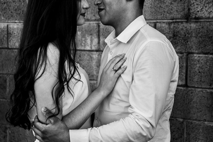 CASAMENTO OU PRE WEDDING REALIZADO EM MARINGA PARANA COM UM CASAL JOVEM A CEU ABERTO NA IMAGEM O CASAL ESTA EM FRENTE AO MURO FOTO EM PRETO E BRANCO