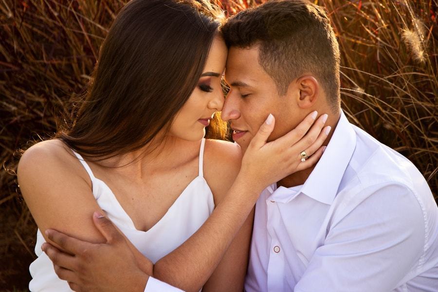 CASAMENTO OU PRE WEDDING REALIZADO EM MARINGA PARANA COM UM CASAL JOVEM A CEU ABERTO NA IMAGEM O CASAL ESTA SENTADO NO CONTRA LUZ E DE OLHOS FECHADOS