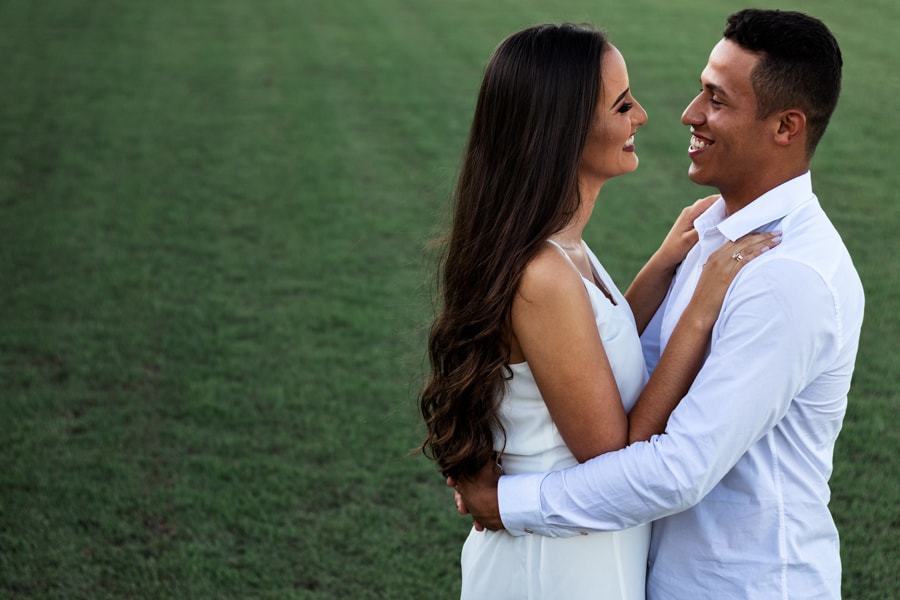 ENSAIO FOTOGRAFICO PRE CASAMENTO OU PRE WEDDING REALIZADO EM MARINGA PARANA COM UM CASAL JOVEM A CEU ABERTO NA IMAGEM O CASAL ESTA EM PE E ABRACADOS SORRINDO