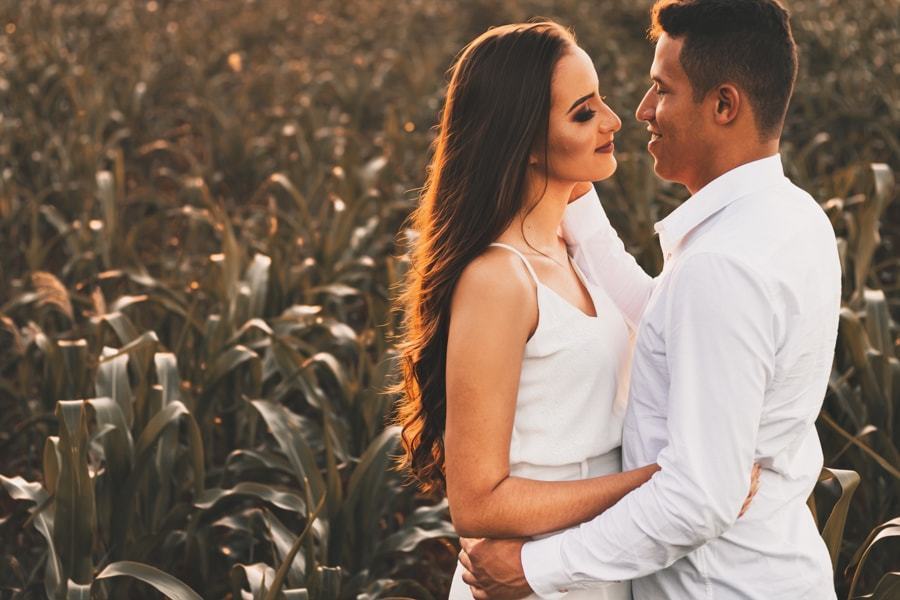 CASAMENTO OU PRE WEDDING REALIZADO EM MARINGA PARANA COM UM CASAL JOVEM A CEU ABERTO NA IMAGEM O CASAL ESTA EM FRENTE A UMA PLANTACAO DE MILHO COM O NOIVO ACARICIANDO O ROSTO DA NOIVA