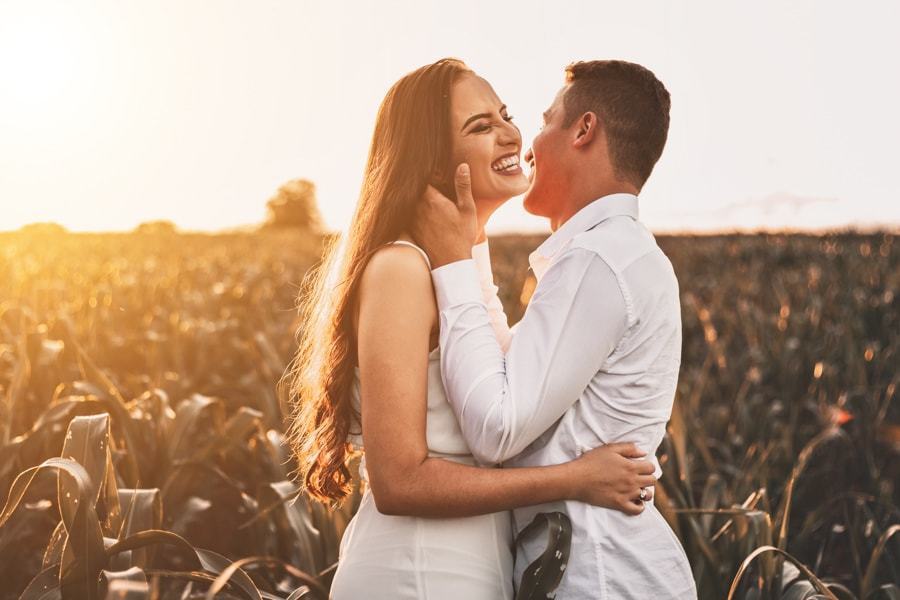 CASAMENTO OU PRE WEDDING REALIZADO EM MARINGA PARANA COM UM CASAL JOVEM A CEU ABERTO NA IMAGEM O CASAL ESTA GARGALHANDO COM O NOIVO CONTANDO UM SEGREDO PARA A NOIVA