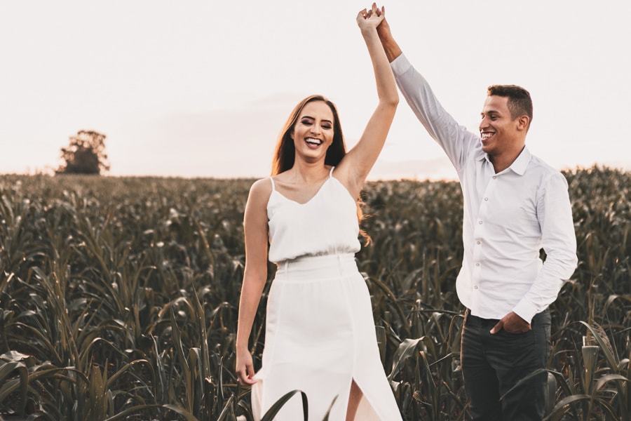 CASAMENTO OU PRE WEDDING REALIZADO EM MARINGA PARANA COM UM CASAL JOVEM A CEU ABERTO NA IMAGEM O CASAL ESTA DANCANDO EM MEIO A PLANTACAO E RINDO BASTANTE