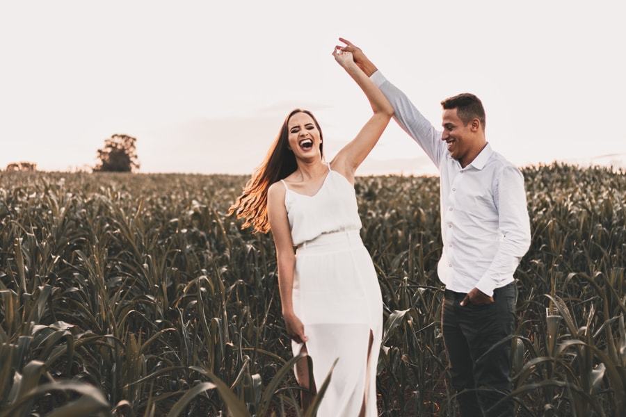 CASAMENTO OU PRE WEDDING REALIZADO EM MARINGA PARANA COM UM CASAL JOVEM A CEU ABERTO NA IMAGEM O CASAL ESTA SE DIVERTINDO MUITO ENQUANTO A NOIVA GARGALHA DANCANDO COM O NOIVO NO MEIO DA PLANTACAO