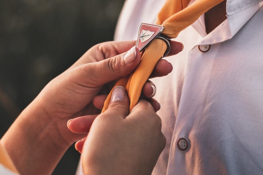 CASAMENTO OU PRE WEDDING REALIZADO EM MARINGA PARANA COM UM CASAL JOVEM A CEU ABERTO NA IMAGEM A NOIVA ESTA AJUSTANDO O LENCO DOS DESBRAVADORES DO NOIVO COM MUITO CARINHO