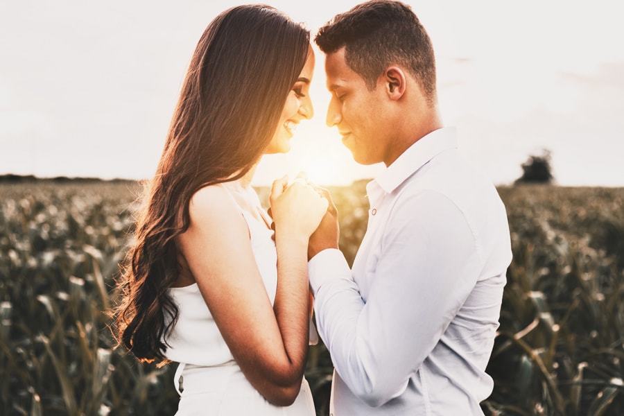 CASAMENTO OU PRE WEDDING REALIZADO EM MARINGA PARANA COM UM CASAL JOVEM A CEU ABERTO NA IMAGEM O CASAL ESTA ORANDO JUNTOS COM O SOL ILUMINANDO OS SEUS ROSTOS