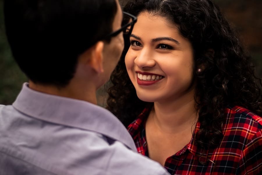 ENSAIO FOTOGRAFICO PRE CASAMENTO OU PRE WEDDING AO AR LIVRE EM BOSQUE DAS GREVILEAS GREVILIAS MARINGA NO PARANA NA IMAGEM DE DETALHE A NOIVA APARECE OLHANDO COM MUITO AMOR PARA O NOIVO