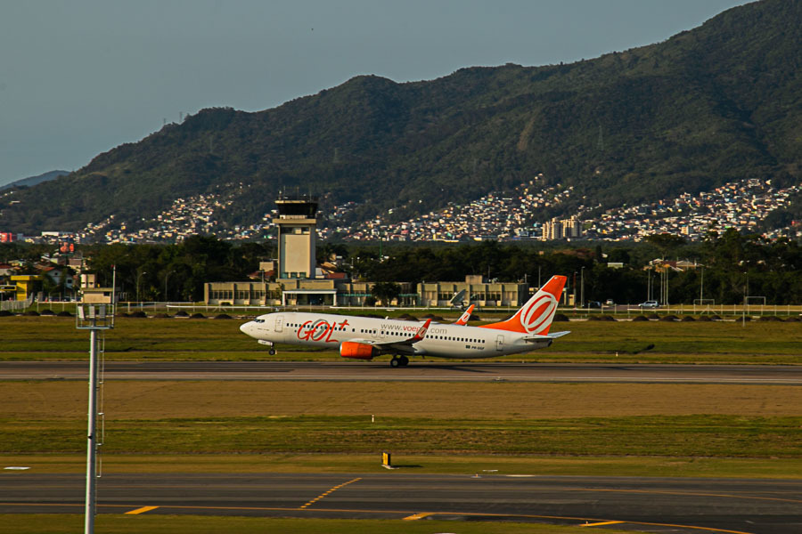 Avião Gol decolando com torre controle de fundo