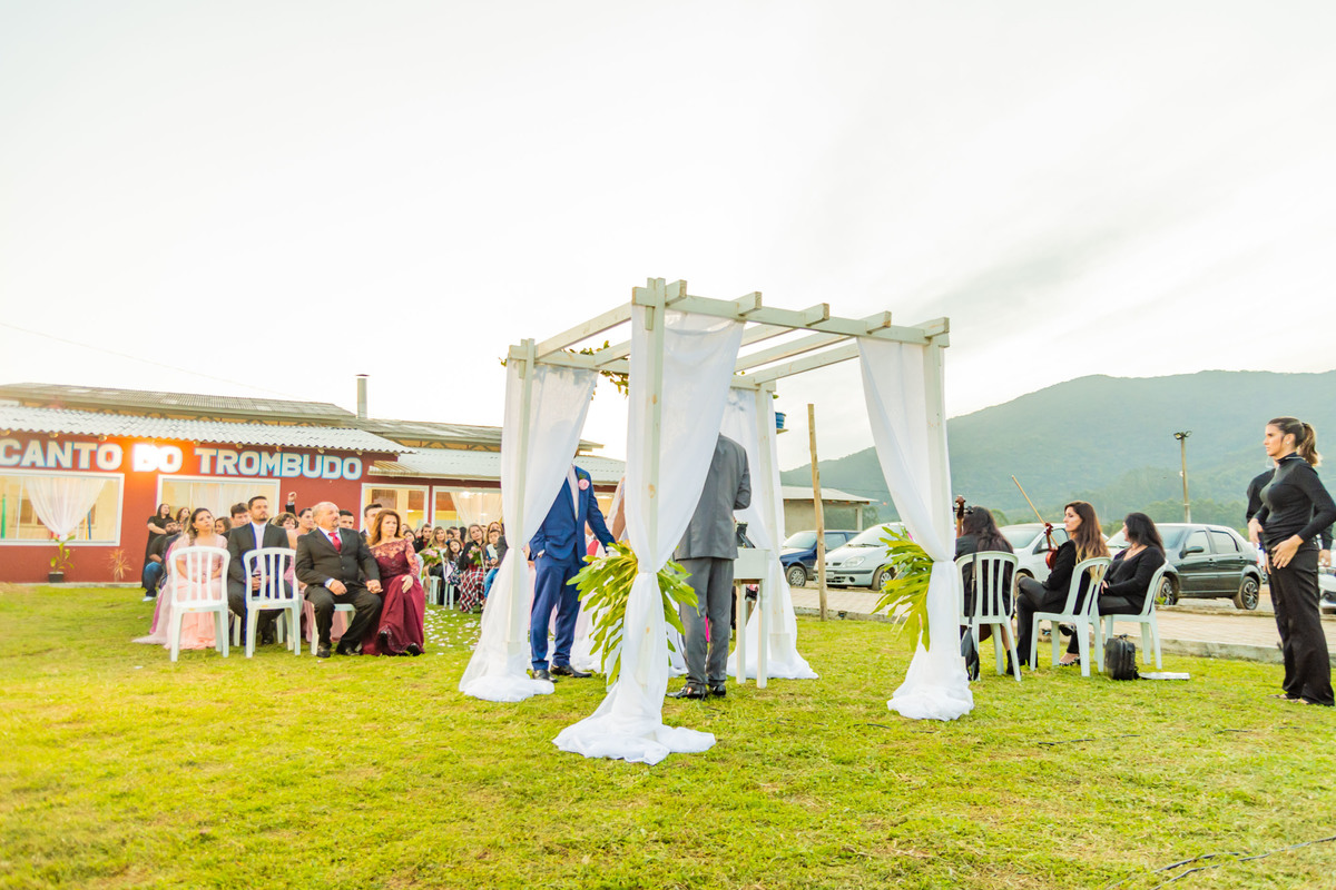 cerimônia de casamento no campo ao por do sol em itapema recanto do trombudo noivo terno azul