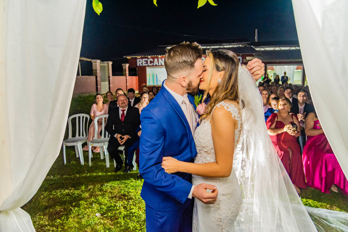 beijo noivos noiva véu longo itapema noivo terno azul casamento na praia