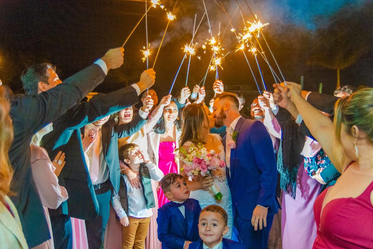 entrada com sparkles noivos noiva véu longo itapema noivo terno azul casamento na praia