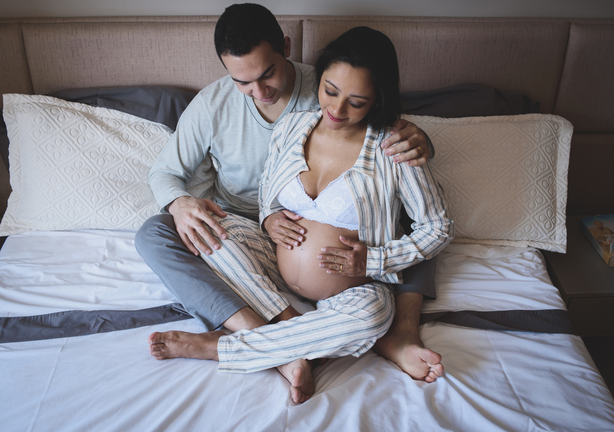 foto de casal gestante na cama