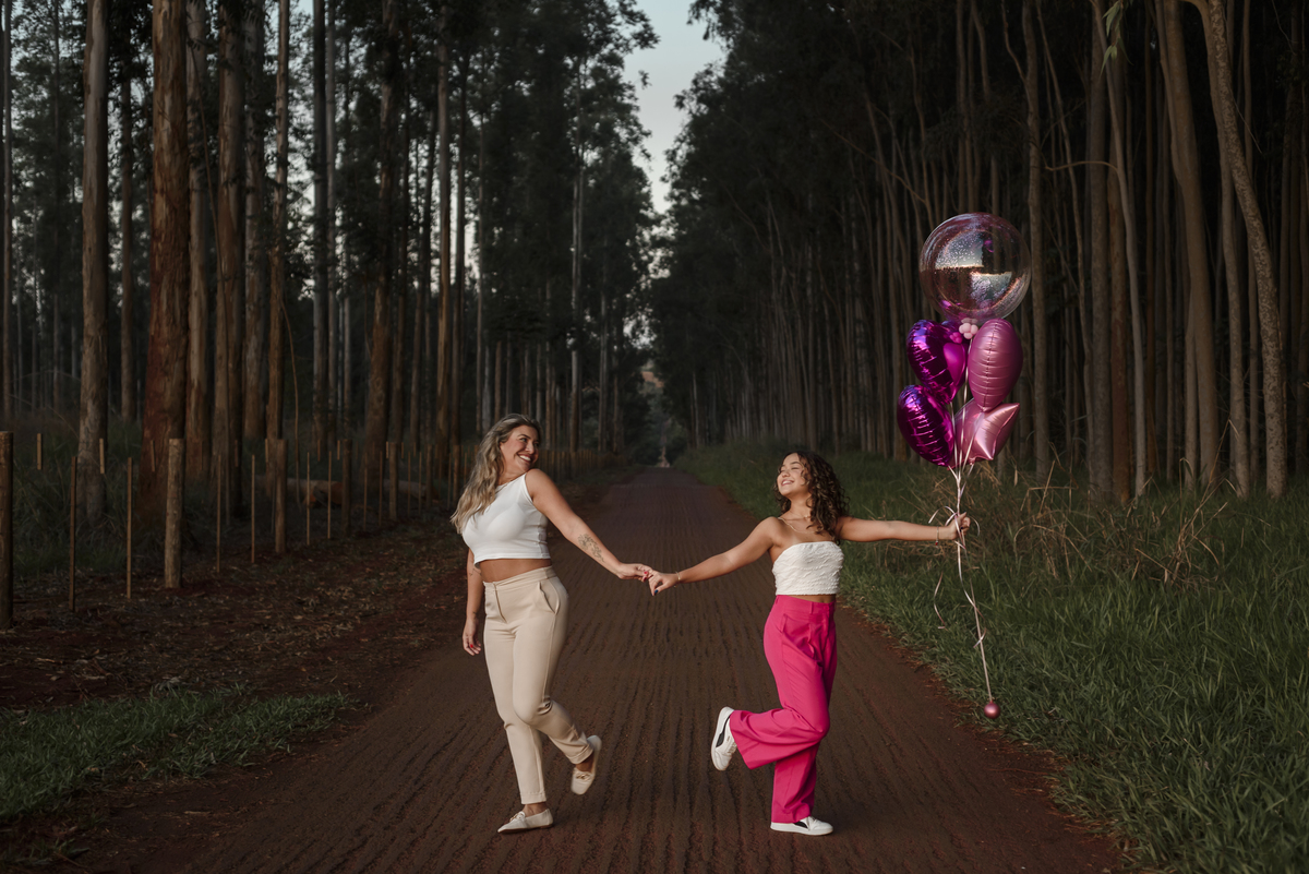 Ensaio fotográfico 15 anos, mãe e filha de mãos dadas.