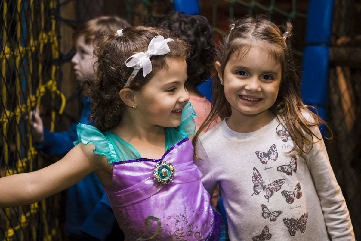Foto da aniversariante feliz com a chegada de sua amiguinha a sua festa de aniversário