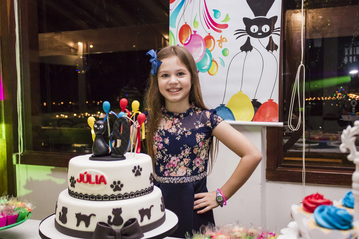 Aniversariante na mesa do bolo com o tema gatinho