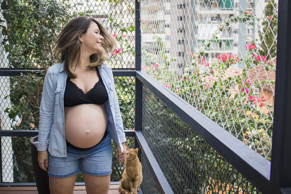 fotografia da gestante na varanda do apartamento