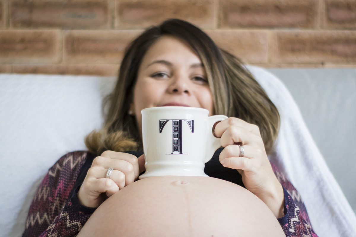 gestante apoiando a xícara na barriga