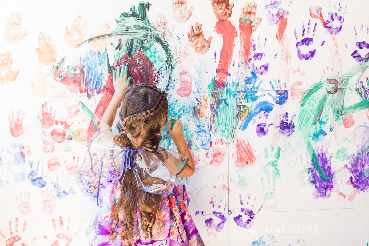 menina se divertindo pintando o muro da creche Jardim em jacarepagua