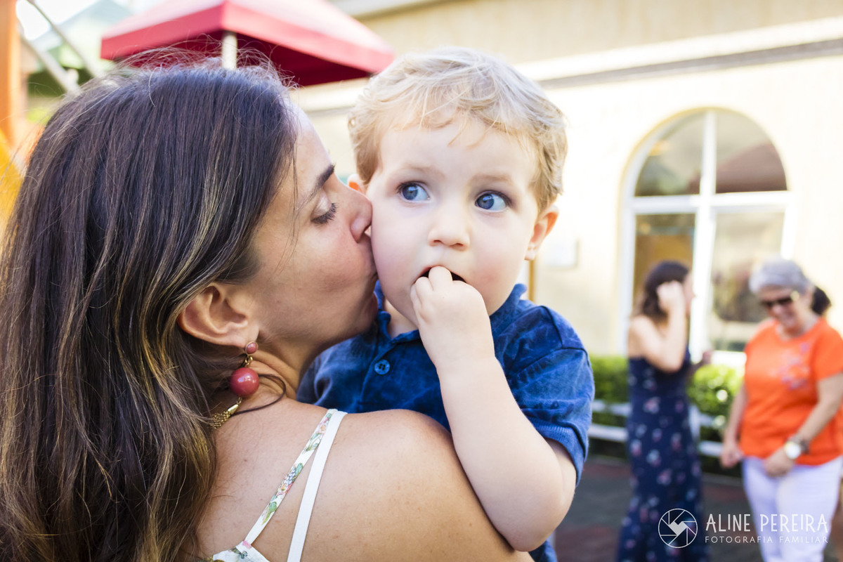 mãe beijando o filho em sua festa de aniversário