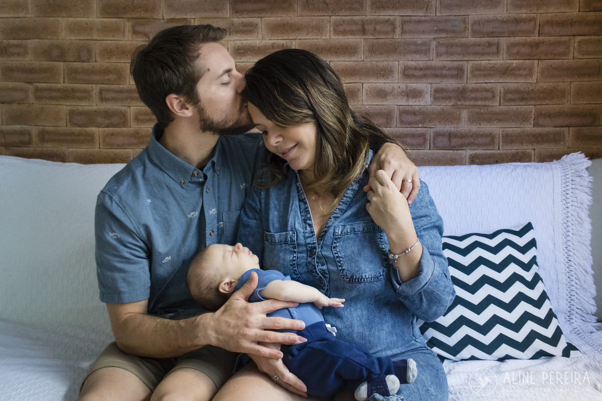 pai, mãe e bebê no sofá