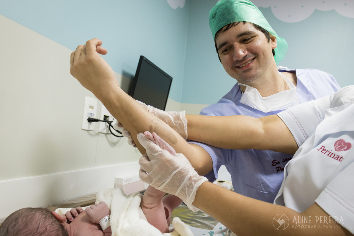 papai sendo carimbado com o pé do bebê recém-nascido