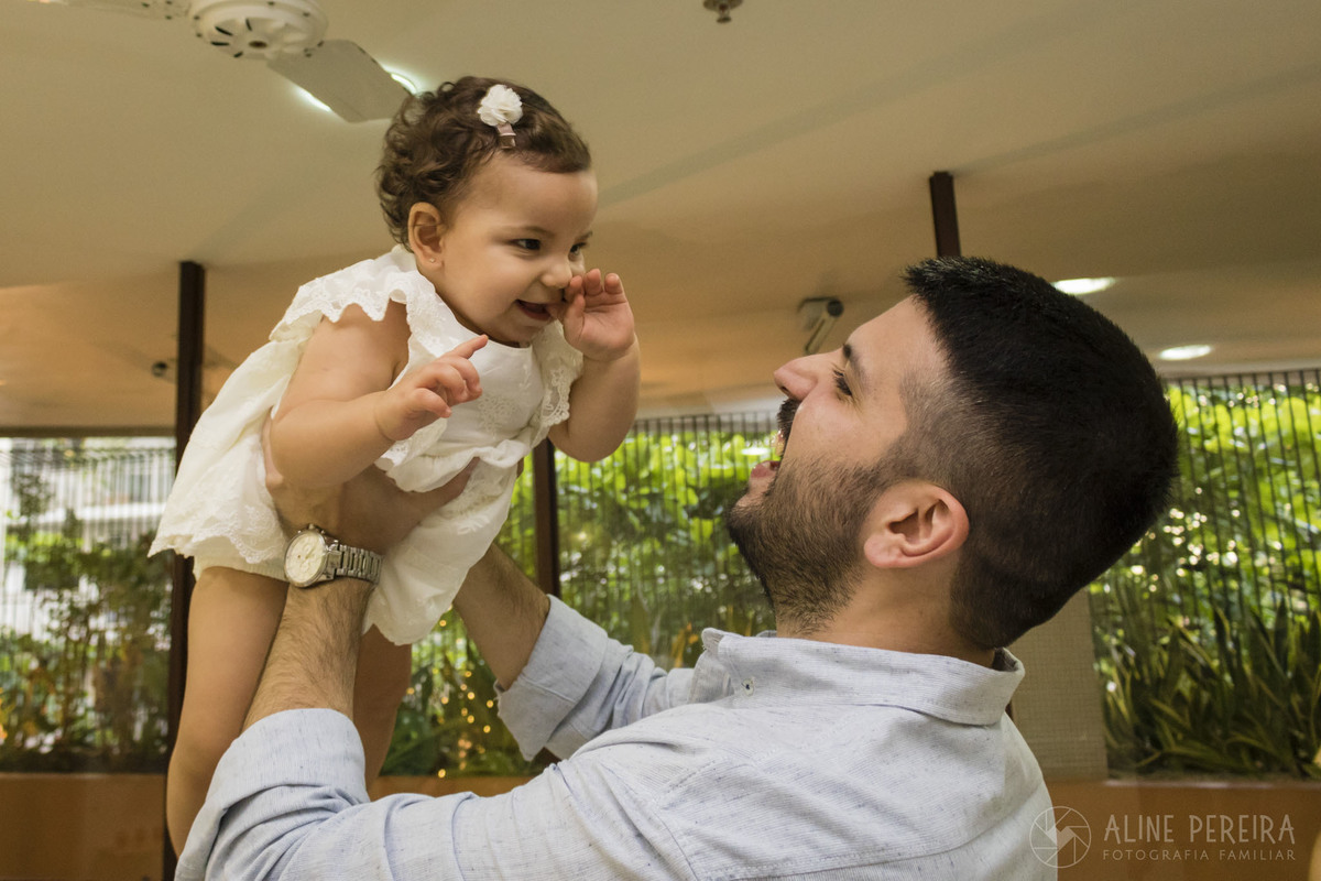 Pai segurando a filha no alto