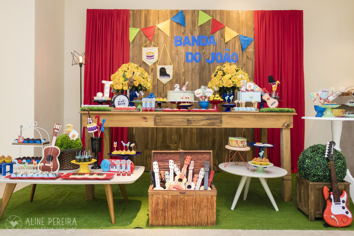 Decoração da mesa do bolo na festa de aniversário com o tem instrumentos musicais e música