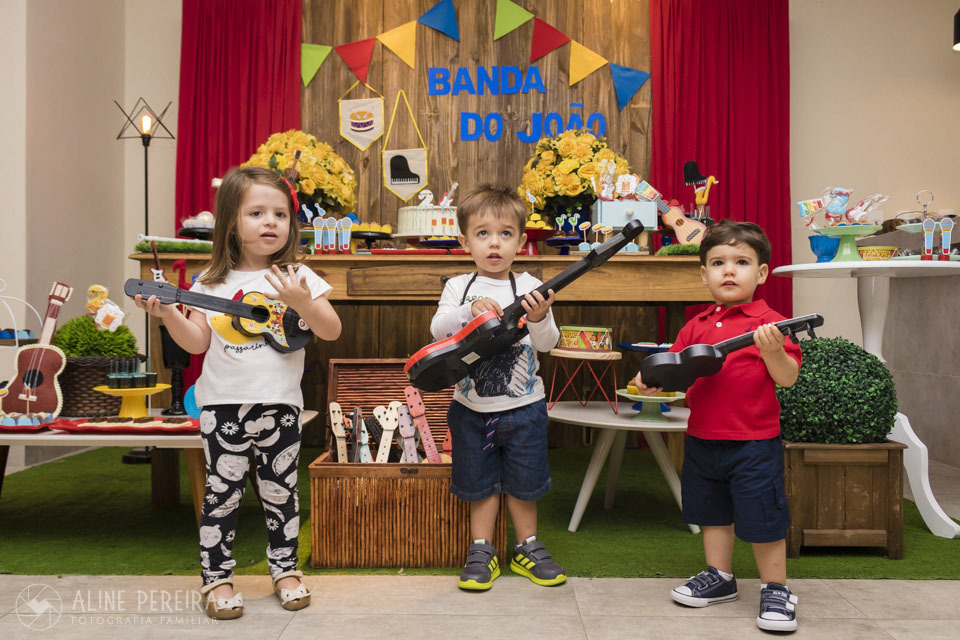 crianças na frente da mesa do bolo decorada com o tema música
