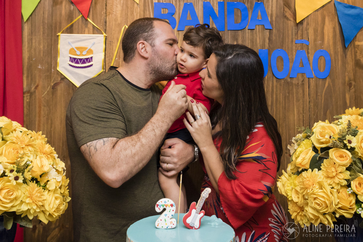 pais e aniversariante na mesa do bolo