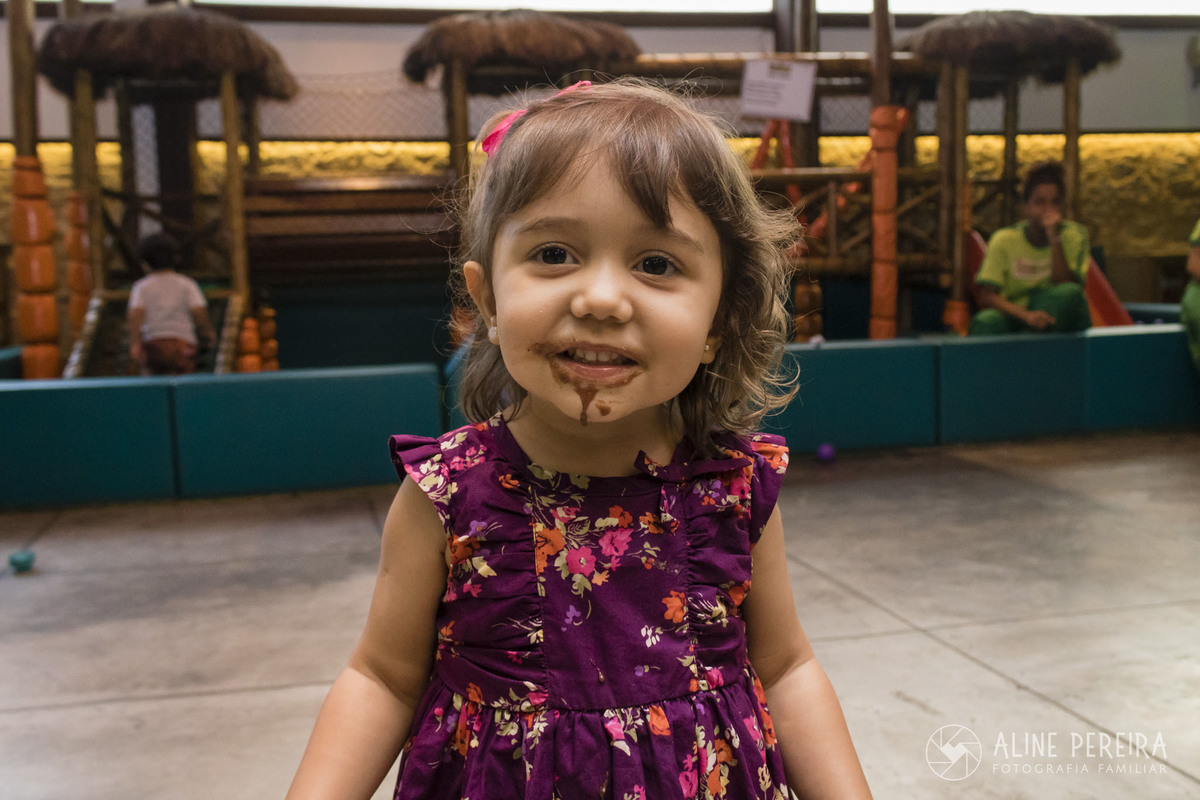 Menina com a boca toda suja de chocolate na festa de aniversario na casa de festas Ecomania