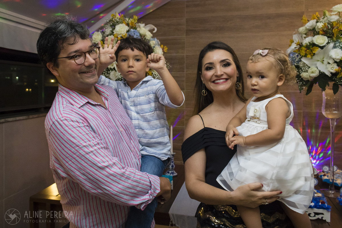 família em frente a mesa do bolo
