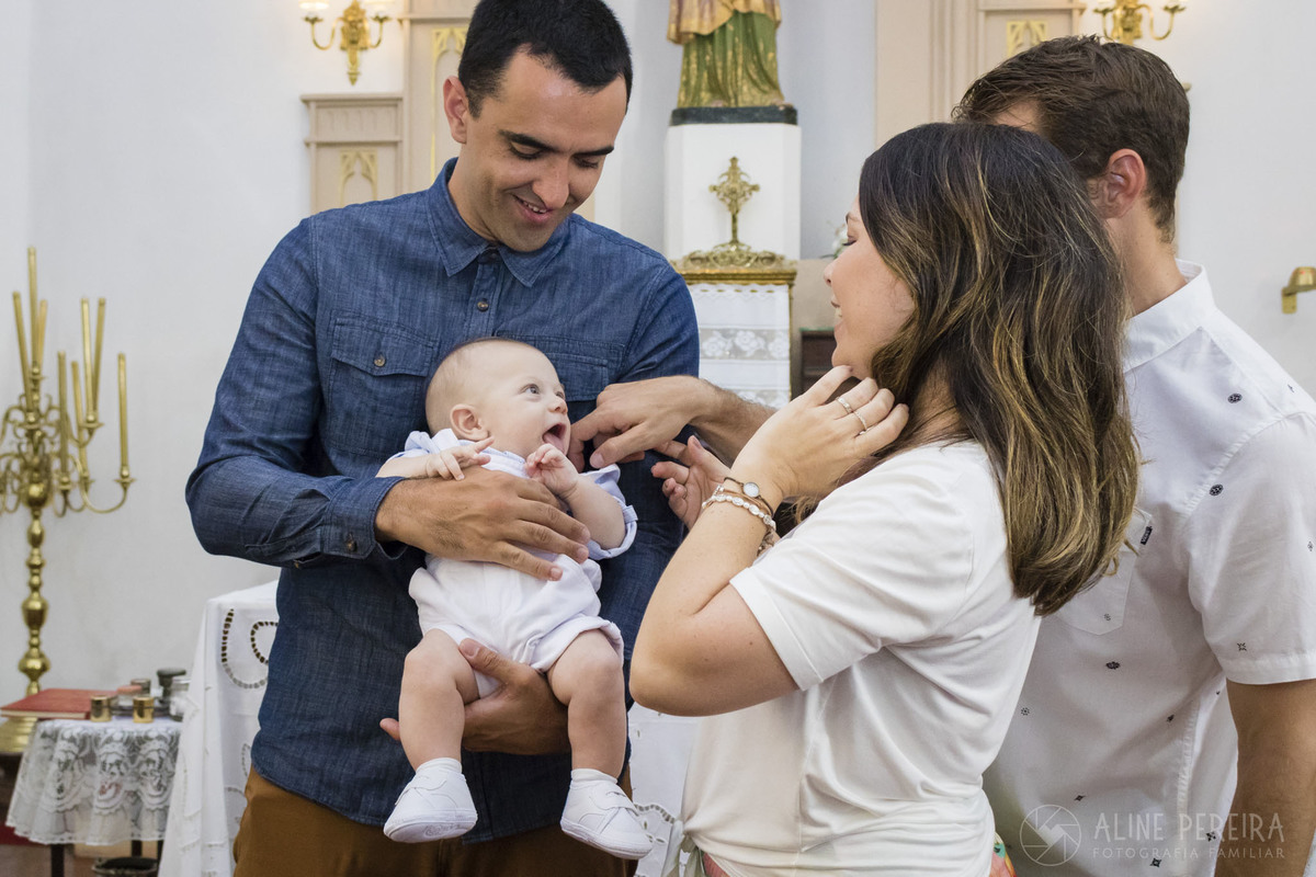 bebê no colo do padrinho na igreja