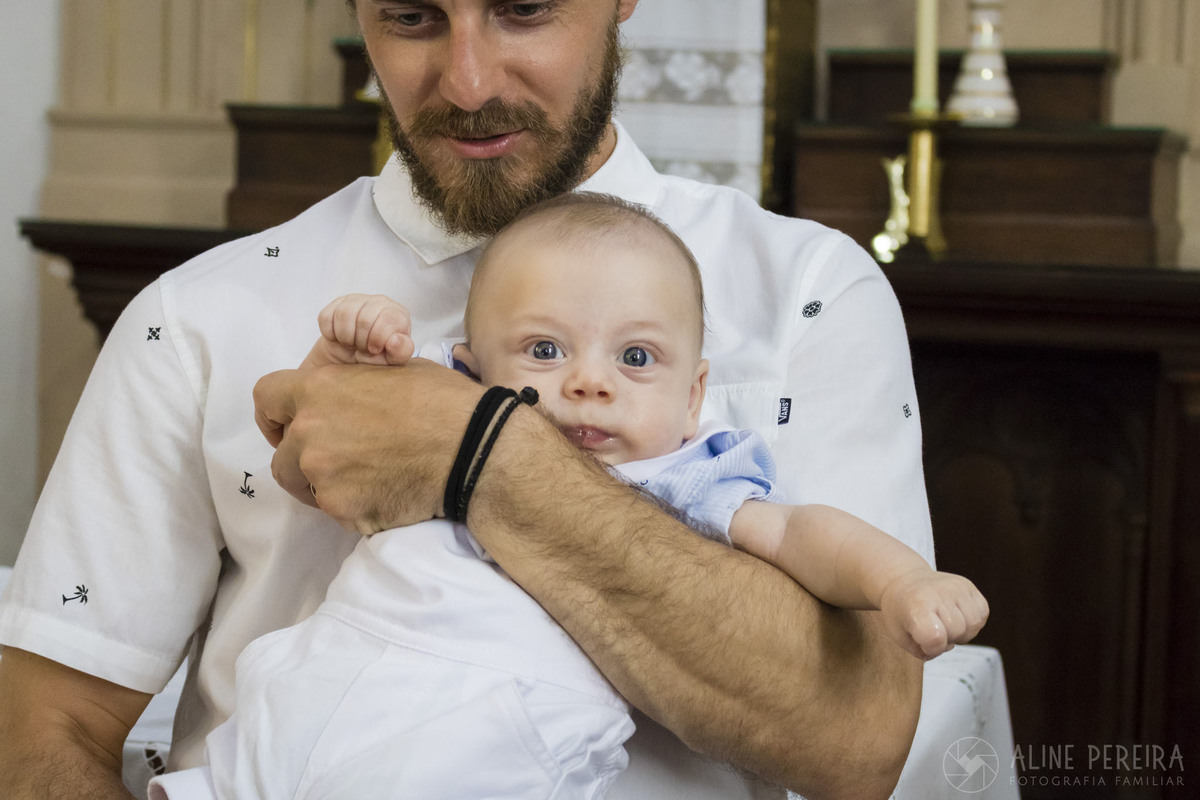 bebê a espera do batizado no colo do pai