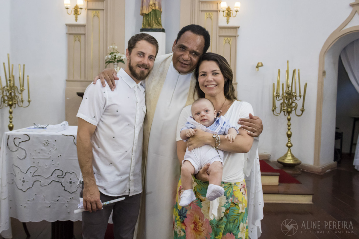 família sendo abraçada pelo padre 