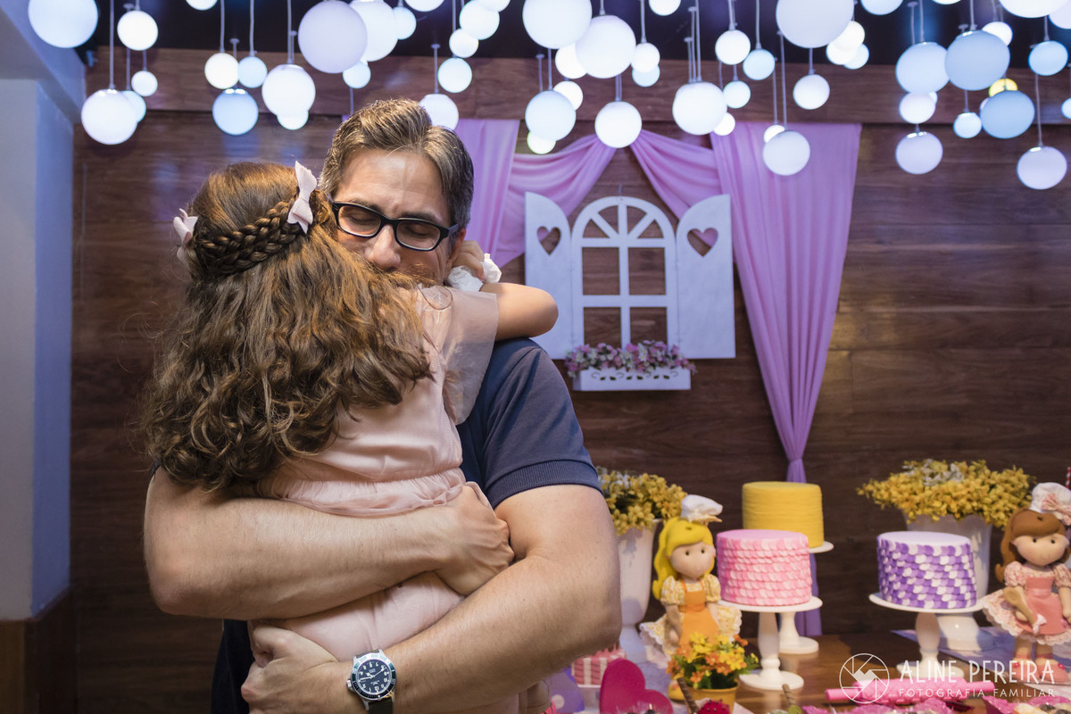 um abraço apertado em frente a mesa do bolo com o tema confeitaria
