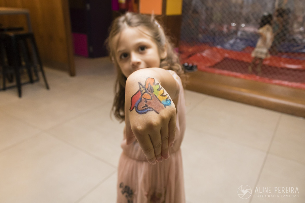 menina mostrando a tatuagem temporária na festa de aniversário