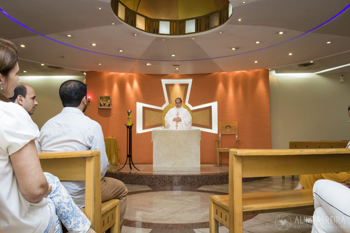 Padre realizando o batizado na capela do colégio santo agostinho no leblon