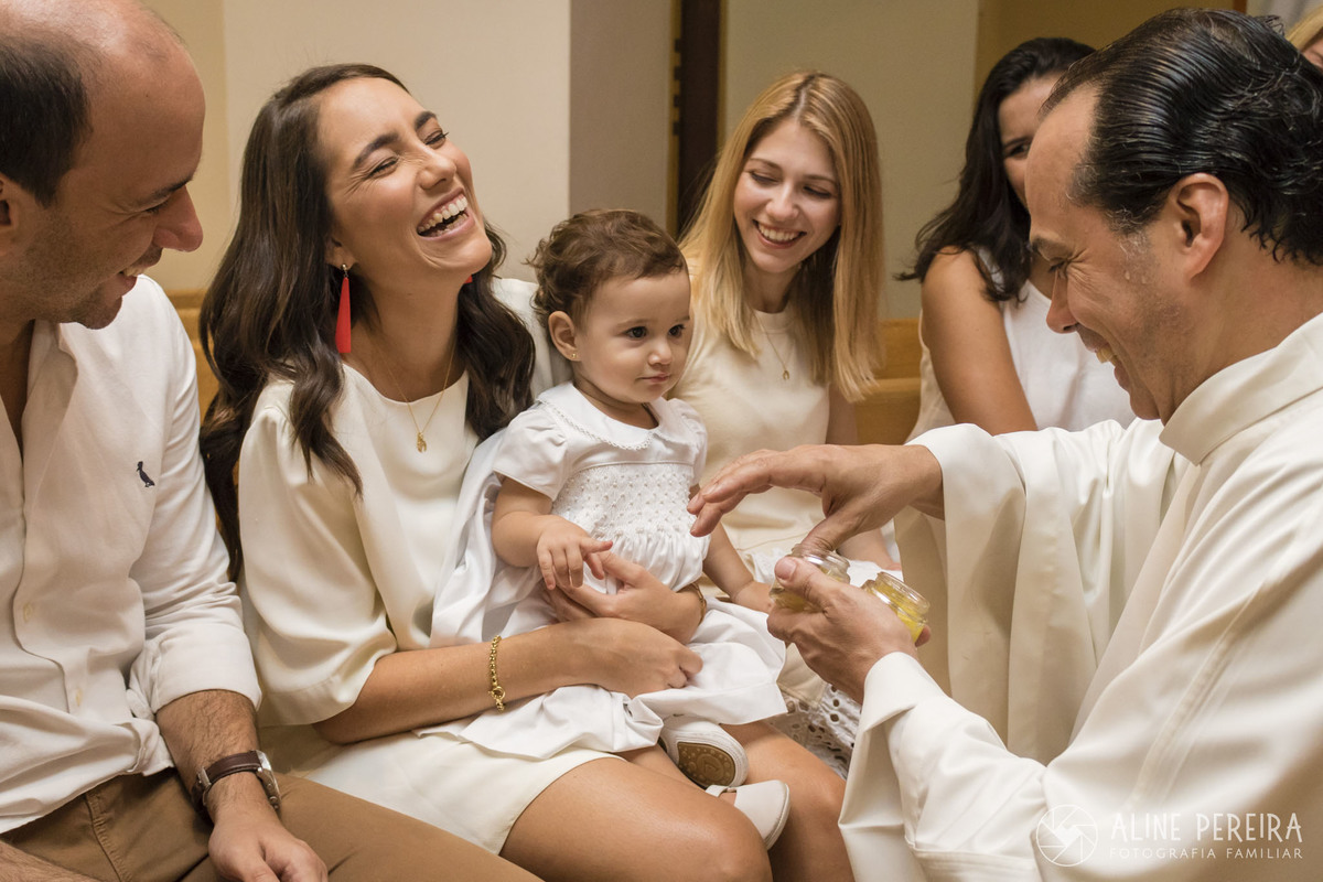 padre abençoando a criança no batizado