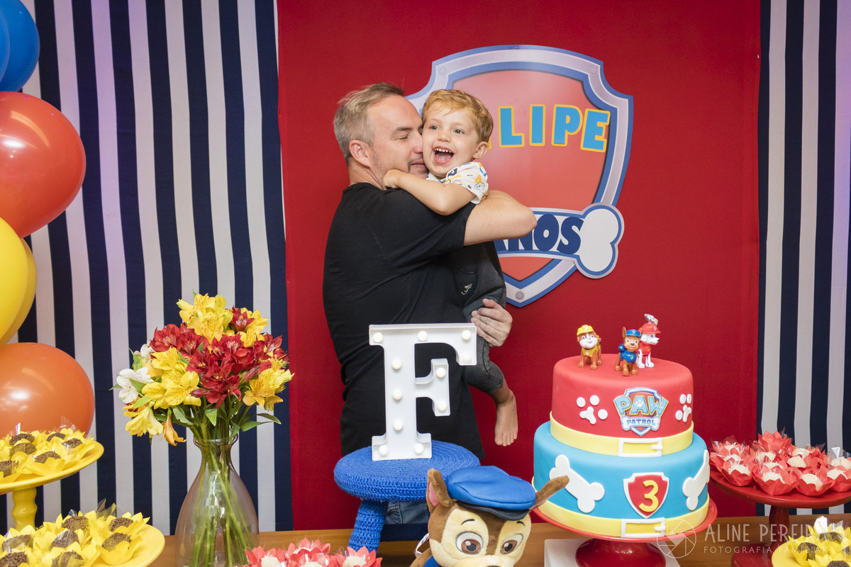 pai e filho na mesa do bolo com o tema patrulha canina