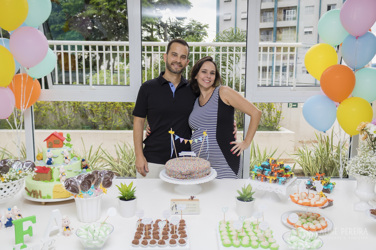grávida e marido na mesa do bolo decorada no chá de bebê
