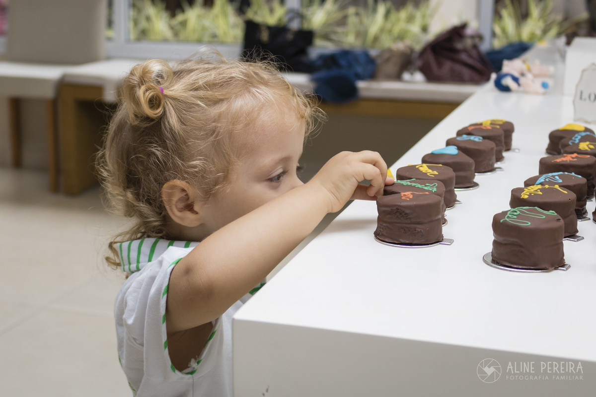 criança roubando doce da mesa no chá de bebê