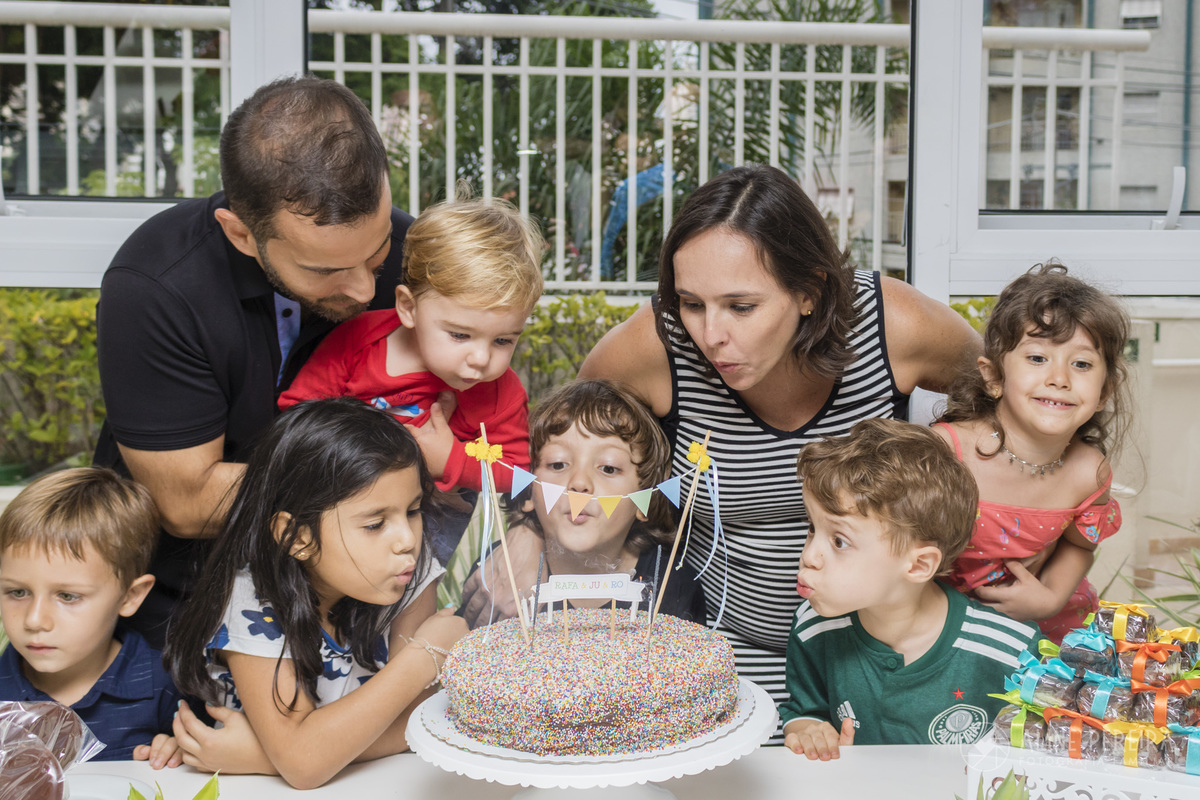 crianças assoprando a vela do bolo no chá de bebê